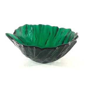 May include: A decorative green glass bowl with a leaf-like shape. The bowl has a textured exterior and a vibrant green interior with black streaks. The rim is dark, creating a contrast. This unique bowl is perfect for home decor.