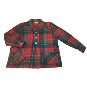 May include: A red, green, and gray plaid blazer with two front pockets and three buttons. The long-sleeved jacket has a collared neckline and is made of a woven fabric.