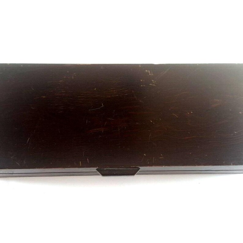 May include: A dark brown wooden box with a hinged lid and a small metal latch. The box has a worn, distressed finish.