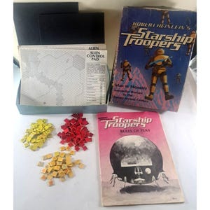 May include: A vintage board game box set of Robert Heinlein's "Starship Troopers." The box is blue with the title in white and yellow. Included are game pieces in red and yellow, a game board, and a rule book.