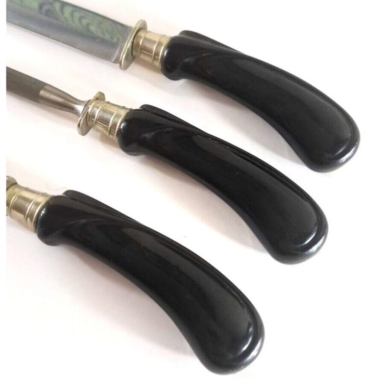 May include: Three black handled knives with silver accents. The blades are not visible in the image.