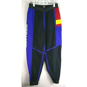 May include: Black, blue, and red athletic pants with the word "CENADOR" printed vertically in white on the left leg. The pants have a color-block design with a small pocket and elastic waistband.