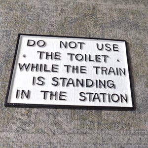 Do Not Use The Toilet While The Train Is Standing In The Station  " Heavy Cast Iron Sign Wall,gate or fence mounting