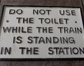 Do Not Use The Toilet While The Train Is Standing In The Station  " Heavy Cast Iron Sign Wall,gate or fence mounting