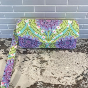 Cartera de mano estilo acordeón con 12 ranuras para tarjetas, 1 compartimento con cremallera, 2 bolsillos y cierre magnético. Tejido Tula Pink Untamed.