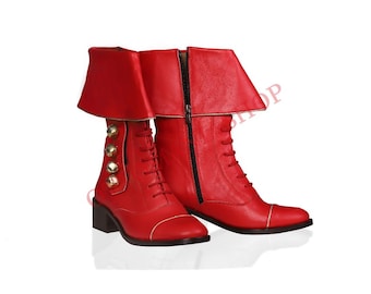 May include: A pair of red leather boots with gold buckles and laces. The boots have a fold-over cuff and a pointed toe.