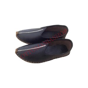 May include: A pair of black leather slip-on shoes with a decorative stitch detail around the toe and heel.