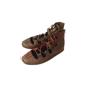 May include: A pair of brown leather sandals with laces that tie up the leg. The sandals have a pointed toe and a flat sole.