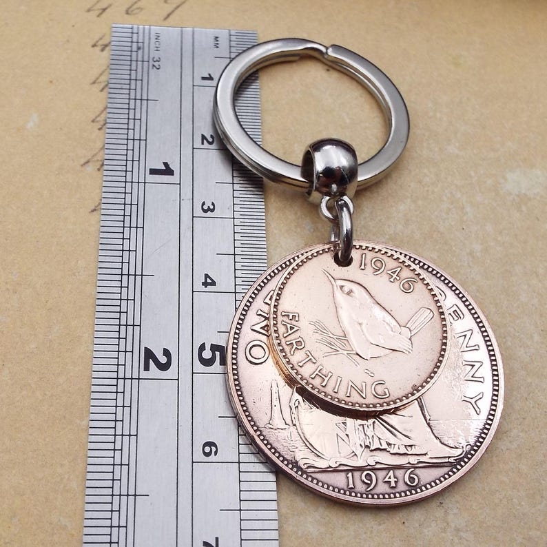 Pu&ograve; includere: Un portachiavi vintage con due monete di rame. La moneta pi&ugrave; grande &egrave; un penny del 1946 e la pi&ugrave; piccola &egrave; un farthing. Il portachiavi ha un anello in metallo color argento. Le monete hanno un diametro di circa 3,2 cm.