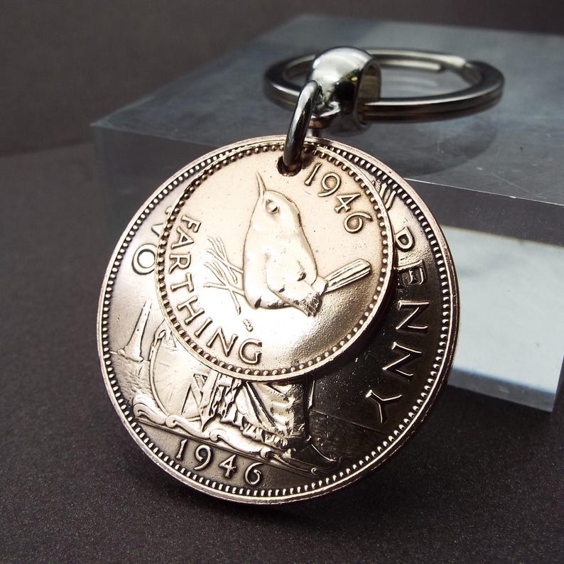 Puede incluir: Un llavero con monedas antiguas, incluyendo un Farthing y un Penny de 1946. El Farthing presenta un p&aacute;jaro, y el Penny un retrato de mujer. El llavero es de metal con un anillo plateado.