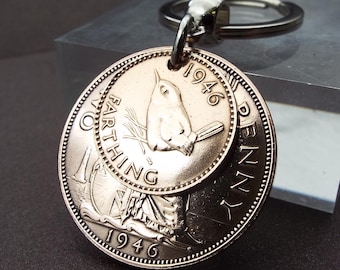 Puede incluir: Llavero con monedas antiguas, incluyendo un Farthing y un Penny de 1946. El Farthing muestra un pájaro, y el Penny a Britannia. El llavero es de metal con un llavero plateado.
