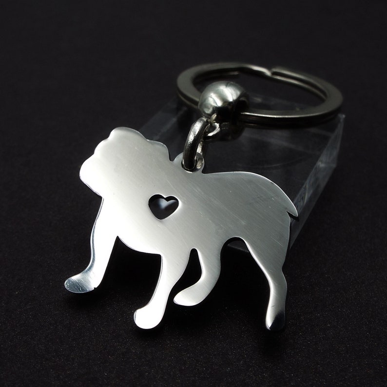 May include: Silver bulldog keychain with a heart cutout. The keychain is attached to a silver key ring.