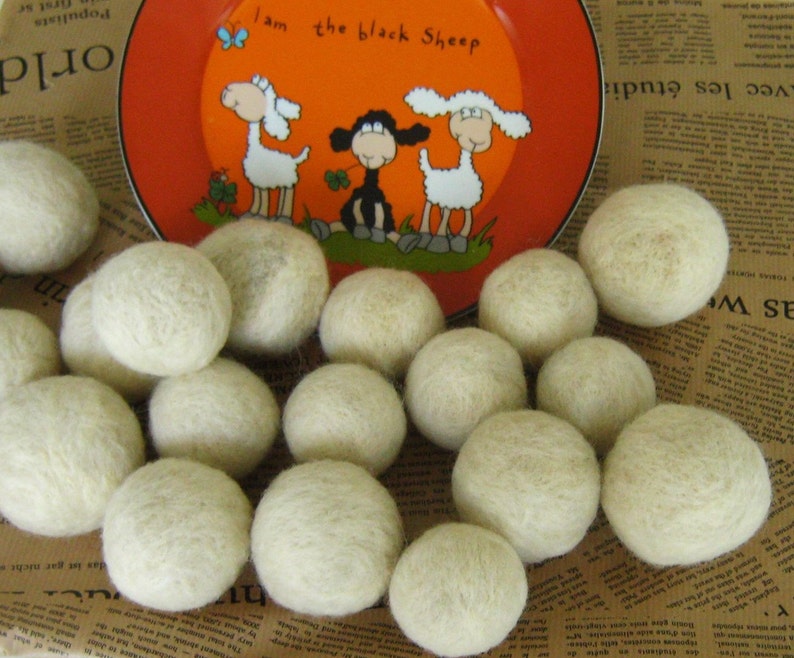 May include: A close-up of a group of white wool dryer balls. The balls are arranged in a circle on a brown and white patterned surface. The balls are soft and fluffy, and they are perfect for adding a natural touch to your laundry routine.