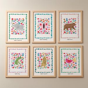 May include: Six framed art prints featuring colorful illustrations of animals and flowers. The prints include a gray elephant, a pink butterfly, a brown bear, a green frog, a yellow leopard, and a pink bird. Each print has a white background with a floral border and the animal's name.