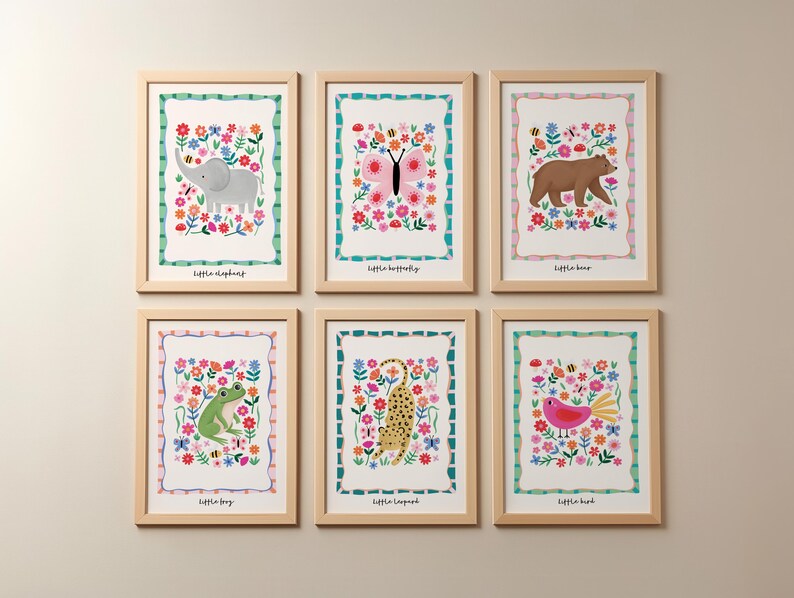 May include: Six framed art prints featuring colorful illustrations of animals and flowers. The prints include a gray elephant, a pink butterfly, a brown bear, a green frog, a yellow leopard, and a pink bird. Each print has a white background with a floral border and the animal's name.