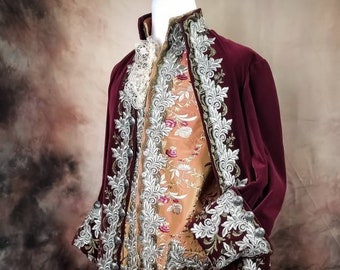 May include: A burgundy velvet jacket with silver embroidery and a floral patterned lining. The jacket has a high collar and long sleeves.