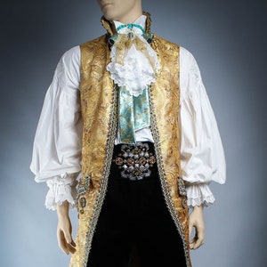 May include: A gold brocade vest with a white lace collar and a turquoise blue bow tie. The vest has a beaded trim and a jeweled belt.
