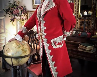 May include: A man wearing a red coat with gold embroidery and a white lace collar. He is wearing a black tricorne hat and black boots. He is standing in a room with a globe and a chair.