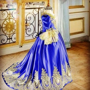 K&ouml;nnte beinhalten: Ein k&ouml;niglich blaues Satin-Ballkleid mit goldener Spitzenverzierung und einem R&uuml;schen&auml;rmel. Das Kleid hat ein tailliertes Oberteil und einen vollen Rock.