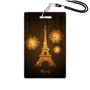 May include: A gold outline of the Eiffel Tower with fireworks exploding around it on a dark brown background. The text "Paris" is below the tower.