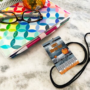 May include: A black lanyard with a Halloween party invitation attached. The invitation is a ticket-style card with a spooky forest scene and a pumpkin. The text on the card reads "Layton's Halloween Party" and includes the date, time, and RSVP information.