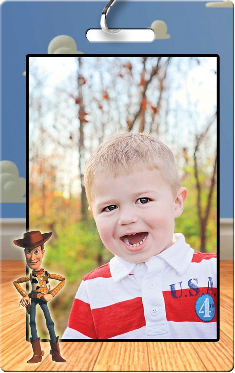Pu&ograve; includere: Un invito a una festa di compleanno blu e bianco con una foto di un bambino piccolo con una camicia a righe rosse e bianche. L'invito presenta un'immagine di cartone animato di Woody di Toy Story e il testo "U.S.A. 4th".