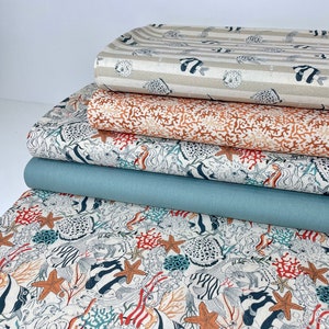 Puede incluir: Una pila de cinco paneles de tela con varios diseños de vida marina. El panel superior es beige con rayas marrones e ilustraciones blancas de caballitos de mar y peces globo. El segundo panel es naranja con un patrón de arrecife de coral. El tercer panel es blanco con ilustraciones de caballitos de mar y peces negros y azules. El cuarto panel es azul turquesa. El panel inferior es blanco con ilustraciones de caballitos de mar y peces negros y azules, coral y estrellas de mar.