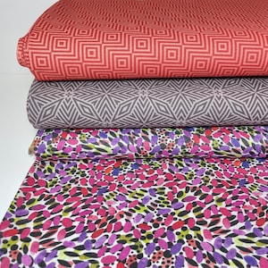 Peut inclure: Trois échantillons de tissu empilés les uns sur les autres. L'échantillon du haut est rouge avec un motif géométrique. L'échantillon du milieu est gris avec un motif géométrique. L'échantillon du bas est blanc avec un motif abstrait coloré.