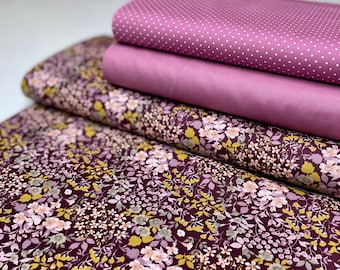 Puede incluir: Un conjunto de cuatro muestras de tela en tonos de rosa y morado. La muestra superior tiene un patrón de lunares blancos, la segunda muestra es de color rosa sólido, la tercera muestra es de color morado sólido y la muestra inferior tiene un patrón floral con flores rosas, moradas y amarillas sobre un fondo morado oscuro.