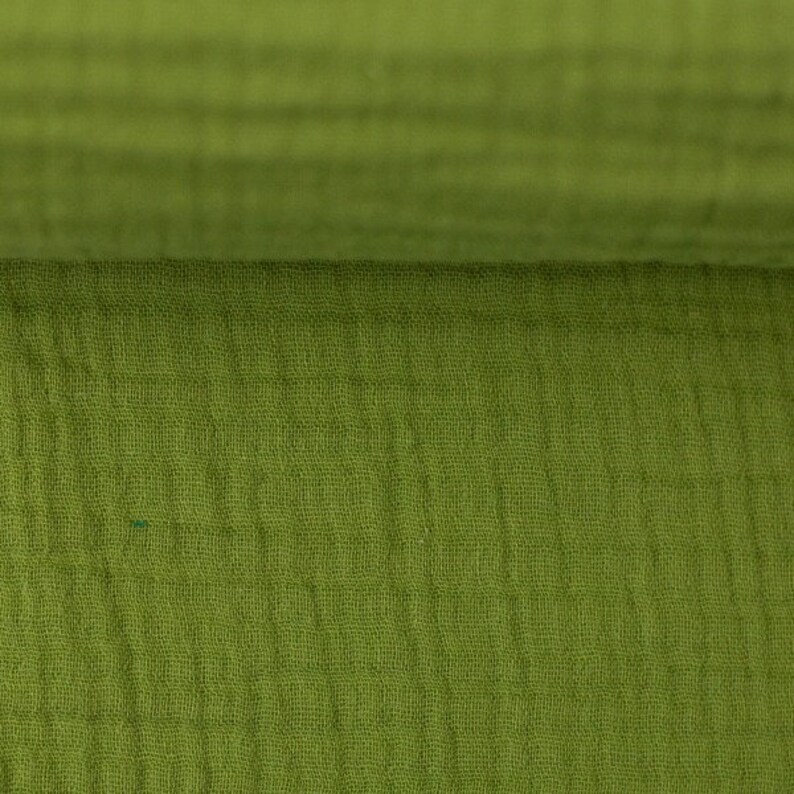 Peut inclure: Gros plan sur un tissu vert avec un motif textur&eacute; en forme de gaufre. Le tissu est doux et a un aspect l&eacute;g&egrave;rement froiss&eacute;.