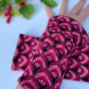 May include: A pair of pink and brown arm warmers with a floral pattern. The warmers are made of a soft, stretchy fabric and are perfect for keeping your arms warm in the cooler months.