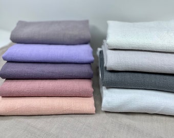 Può includere: Un mucchio di sei campioni di tessuto di lino di diversi colori. I colori sono grigio, lavanda, viola, rosa, pesca e bianco.