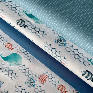 Può includere: Un set di quattro campioni di tessuto a tema nautico. Il campione superiore è un tessuto blu chiaro con strisce bianche. Il secondo campione è un tessuto bianco con un motivo a onde blu e bianche e una varietà di creature marine, tra cui pesci, balene e tartarughe. Il terzo campione è un tessuto blu scuro tinta unita. Il campione inferiore è un tessuto bianco con un motivo a onde blu e bianche e una varietà di creature marine, tra cui pesci, balene e tartarughe.