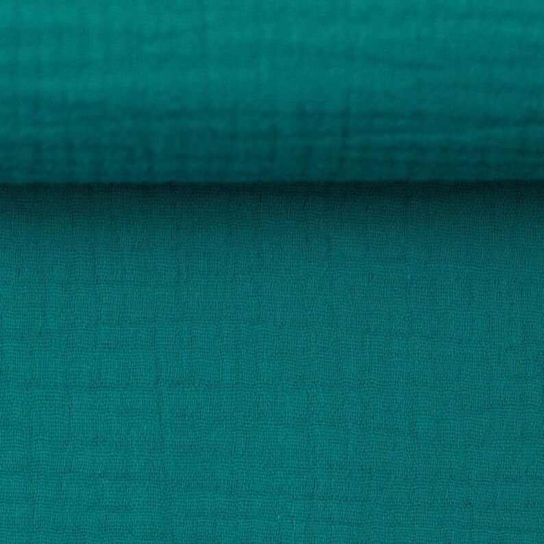 Peut inclure: Gros plan sur un tissu bleu sarcelle avec un motif tiss&eacute; textur&eacute;.