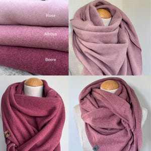 Pode incluir: Lenços macios e quentes em tons de rosa e roxo. Os lenços são exibidos em vários estilos, incluindo drapeados e enrolados. A imagem também mostra um close-up do tecido com os nomes das cores: Rosa, Altrosa e Beere.