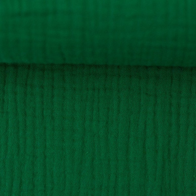 Peut inclure: Gros plan sur un tissu vert fonc&eacute; avec un motif textur&eacute; et tiss&eacute;.