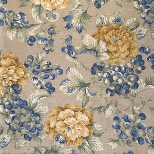Puede incluir: Una tela beige con un patrón floral con flores amarillas y uvas azules. La tela tiene una textura sutil.