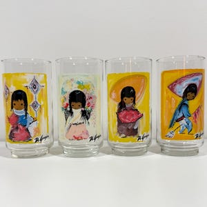 Może przedstawiać: Cztery zabytkowe szklanki do picia z ręcznie malowanymi ilustracjami dzieci w różnych strojach. Każda szklanka ma inny wzór na żółtym tle. Szklanki są przezroczyste i mają prosty, cylindryczny kształt.