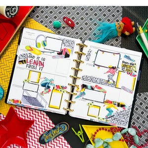 May include: A close-up of a planner with a skateboarding theme. The planner has a yellow cover and is open to the February 2025 calendar. The pages are filled with stickers of skateboarders, skateboards, and other skateboarding-related items. The text "Land it or Learn from it" and "Fear the Regret, Not the Fall" are visible on the pages.