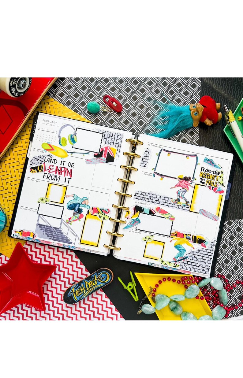 May include: A close-up of a planner with a skateboarding theme. The planner has a yellow cover and is open to the February 2025 calendar. The pages are filled with stickers of skateboarders, skateboards, and other skateboarding-related items. The text "Land it or Learn from it" and "Fear the Regret, Not the Fall" are visible on the pages.