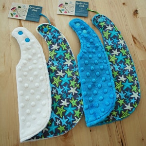 May include: Three baby bibs with a blue and green starfish pattern. One bib is white, one is blue, and one is blue with a white dot pattern. The bibs have a snap closure.