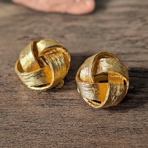 Textured gold-tone metal bow clip-on earrings in Hollywood Regency style, chic and elegant vintage jewelry for women from the 1960s