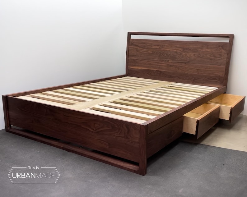 Puede incluir: Un marco de cama de madera marr&oacute;n oscuro con una cabecera y cajones de almacenamiento integrados. El marco de la cama tiene una base de listones y un dise&ntilde;o moderno.