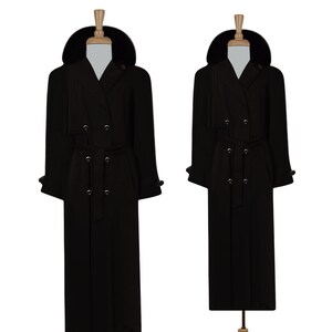 May include: A long black double-breasted coat with a fur collar and a belt. The coat has a classic trench coat style.