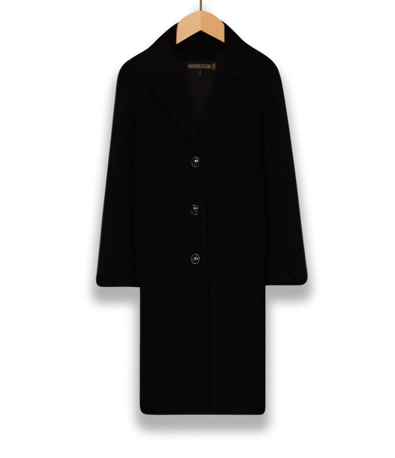 May include: A black long-sleeved coat with a button closure and a label that reads "Kristen Blake".