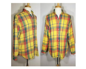 Puede incluir: Una camisa de manga larga con botones y un estampado de cuadros amarillo, rojo, verde y azul.