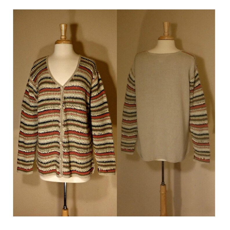 May include: A striped cardigan sweater with a button-up front. The sweater is made of a soft, crocheted material and has a beige, brown, and red color scheme.