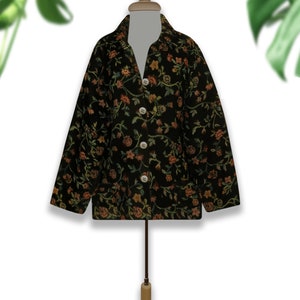 May include: A black jacket with a floral pattern in shades of orange, green, and yellow. The jacket has a button-up front and long sleeves.