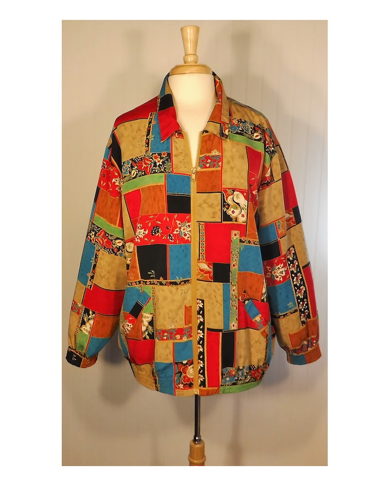 May include: A colorful patchwork jacket with a zipper closure. The jacket features a variety of floral and geometric patterns in shades of red, blue, green, black, and brown.
