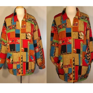 May include: A colorful, patchwork-style jacket with a zipper closure. The jacket features a variety of geometric shapes and floral patterns in shades of red, blue, green, black, and brown.